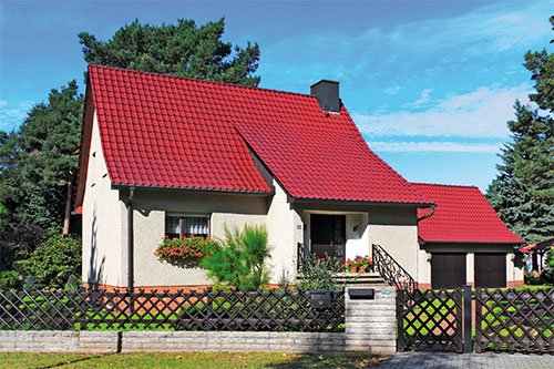 Ein Einfamilienhaus mit rotem Dach als Musterimmobilie.